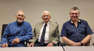 Three men sitting in a row